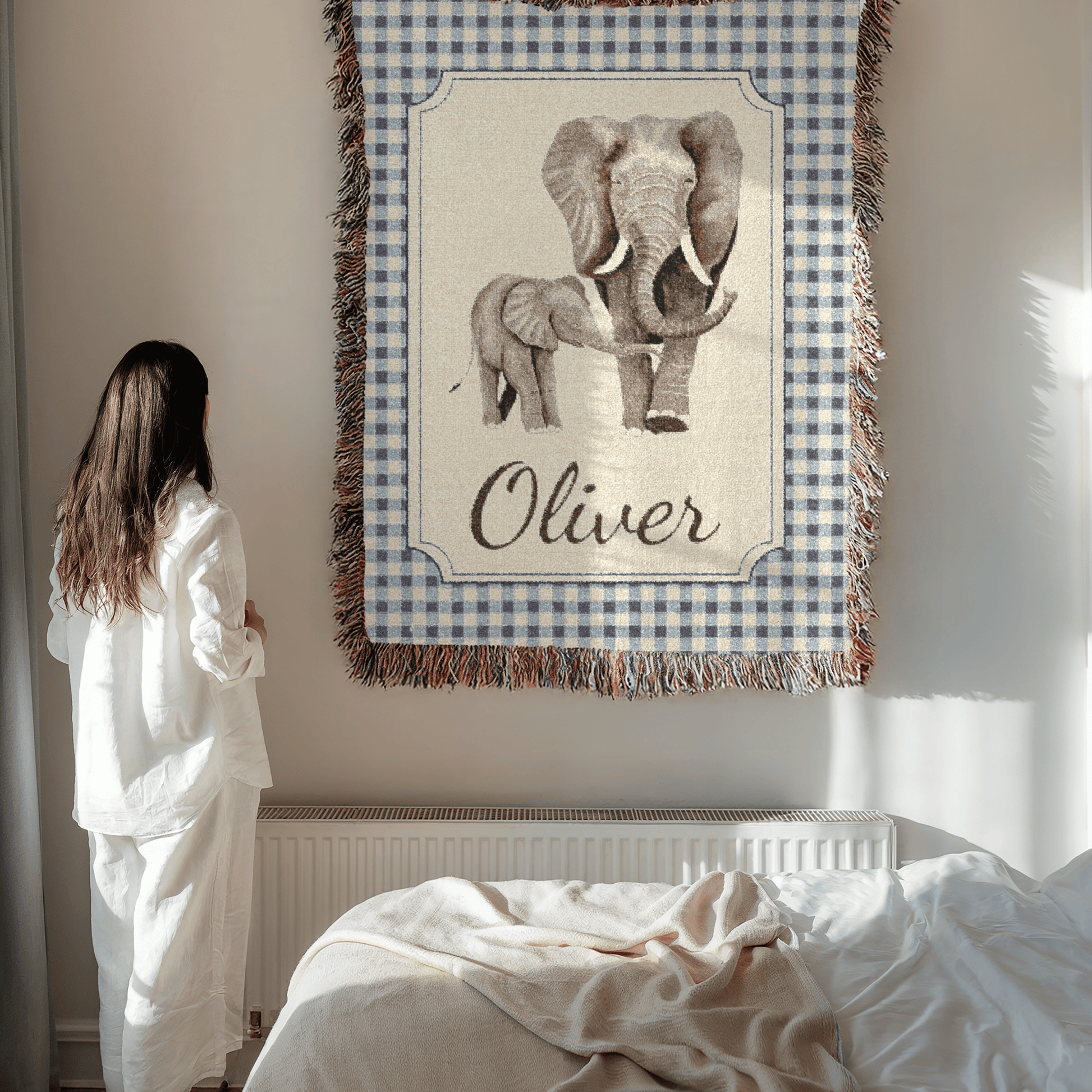 Mother holding the personalized elephant baby blanket beside a bed