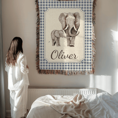Mother holding the personalized elephant baby blanket beside a bed