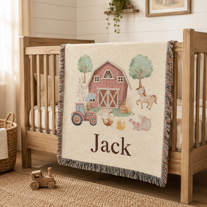 Personalized farm baby blanket draped over the rail of a wooden crib