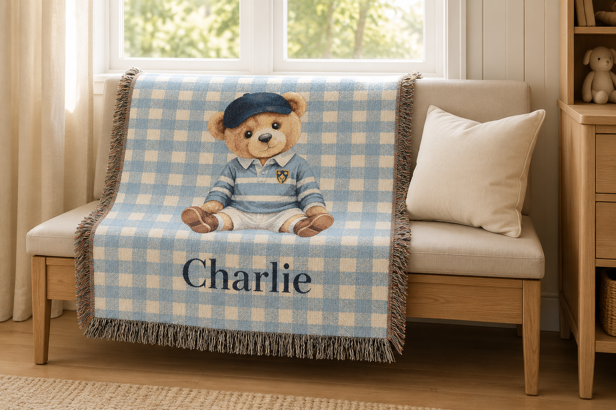 Personalized teddy bear baby blanket over a cream armchair beside a window