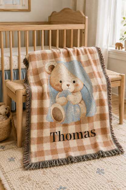 Personalized teddy bear baby blanket over the rail of a wooden crib in a nursery