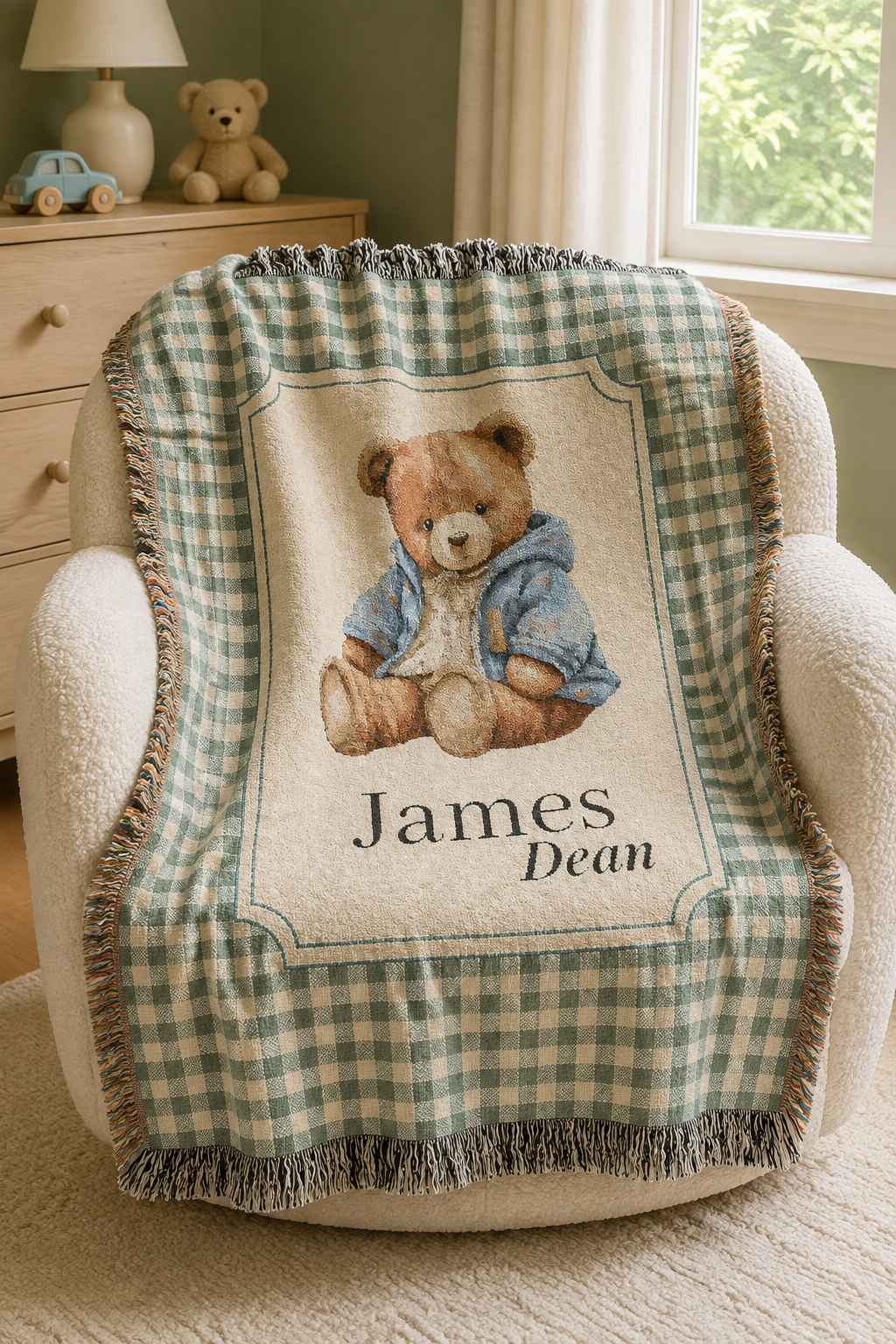 Personalized teddy bear baby blanket over a cream armchair in a nursery