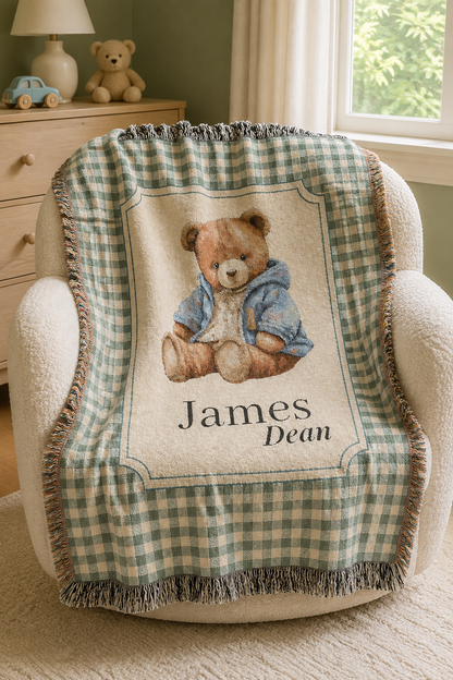 Personalized teddy bear baby blanket over a cream armchair in a nursery