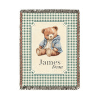 Personalized woven baby blanket with a teddy bear in a blue jacket on sage gingham, with a first and middle name woven in, shown flat