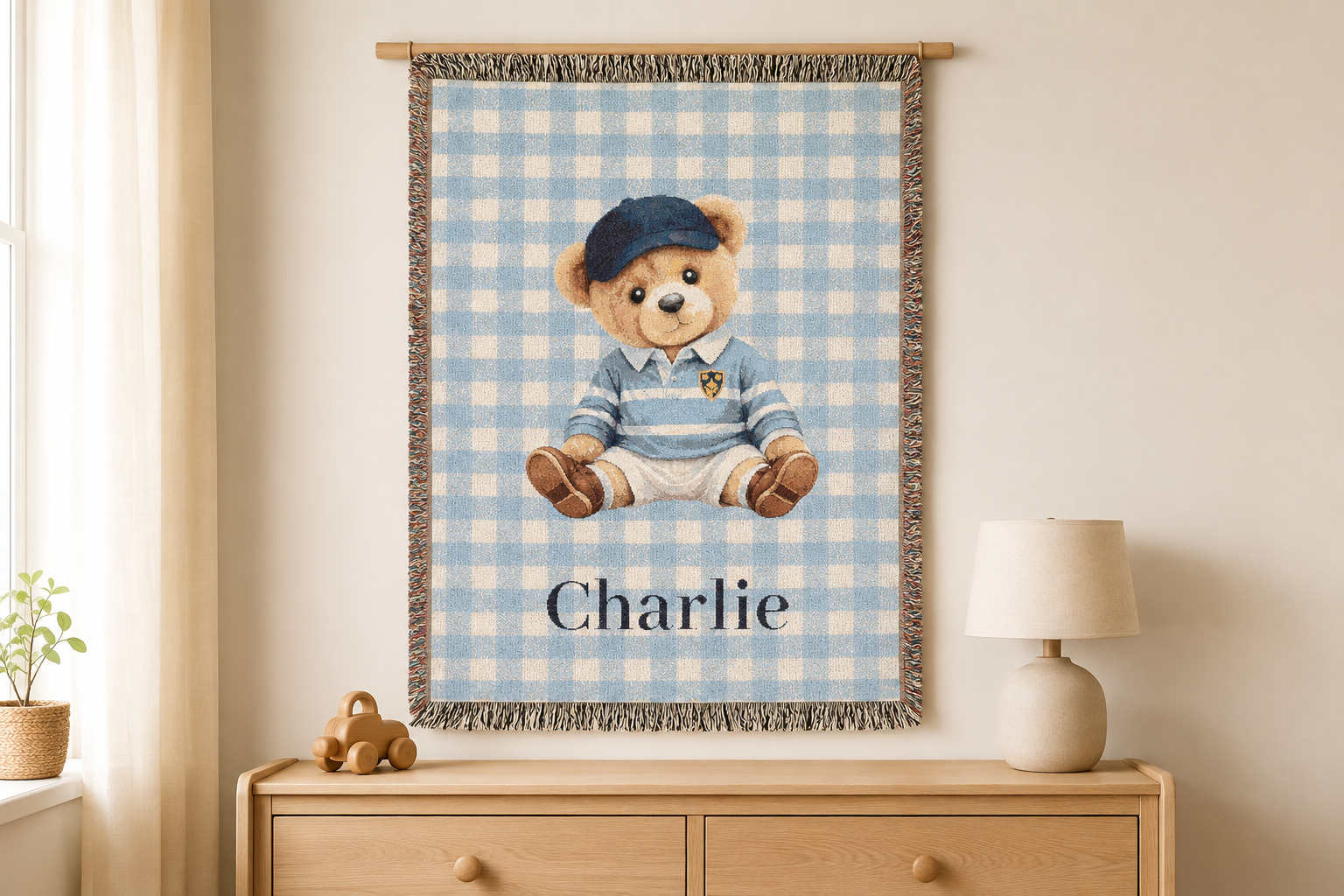 Personalized teddy bear baby blanket hung on the wall above a wooden dresser