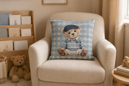 Teddy bear baby pillow on a cream nursery chair with shelves and soft toys behind
