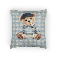 Woven baby pillow with a teddy bear in a navy cap and blue sweater on blue gingham, front view