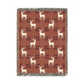 Reindeer plaid woven blanket featuring cream reindeer silhouettes on a rust buffalo-check pattern