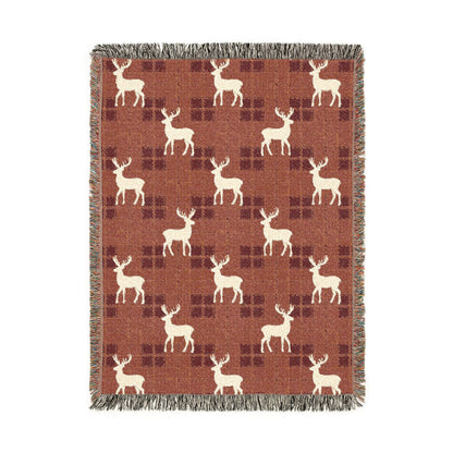 Reindeer plaid woven blanket featuring cream reindeer silhouettes on a rust buffalo-check pattern