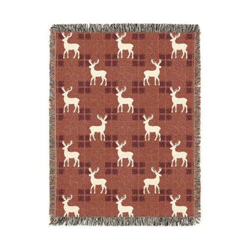 Reindeer plaid woven blanket featuring cream reindeer silhouettes on a rust buffalo-check pattern