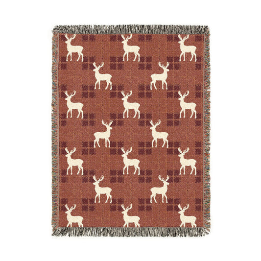 Reindeer plaid woven blanket featuring cream reindeer silhouettes on a rust buffalo-check pattern