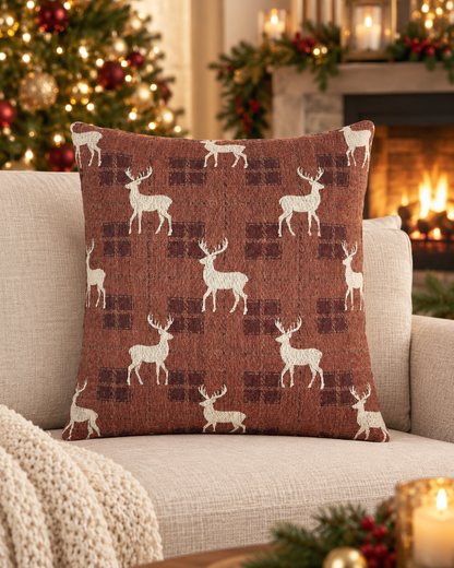 Reindeer plaid woven pillow styled on a couch near a decorated Christmas tree