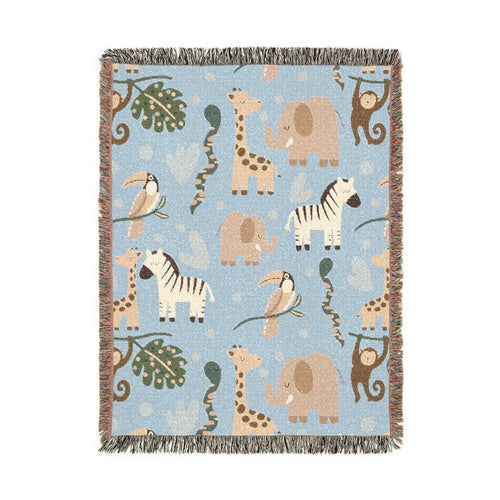 Dusty blue woven blanket with elephants, giraffes, zebras, monkeys and toucans among palm leaves, shown flat