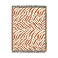 Safari woven blanket in cream with rust and terracotta zebra stripes, shown flat