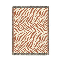 Safari woven blanket in cream with rust and terracotta zebra stripes, shown flat