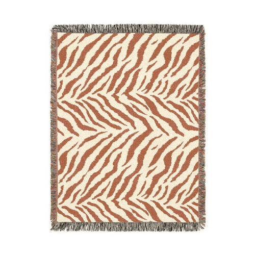Safari woven blanket in cream with rust and terracotta zebra stripes, shown flat