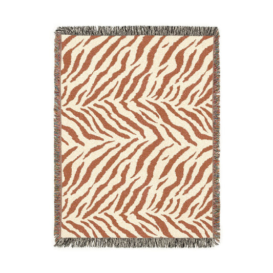 Safari woven blanket in cream with rust and terracotta zebra stripes, shown flat