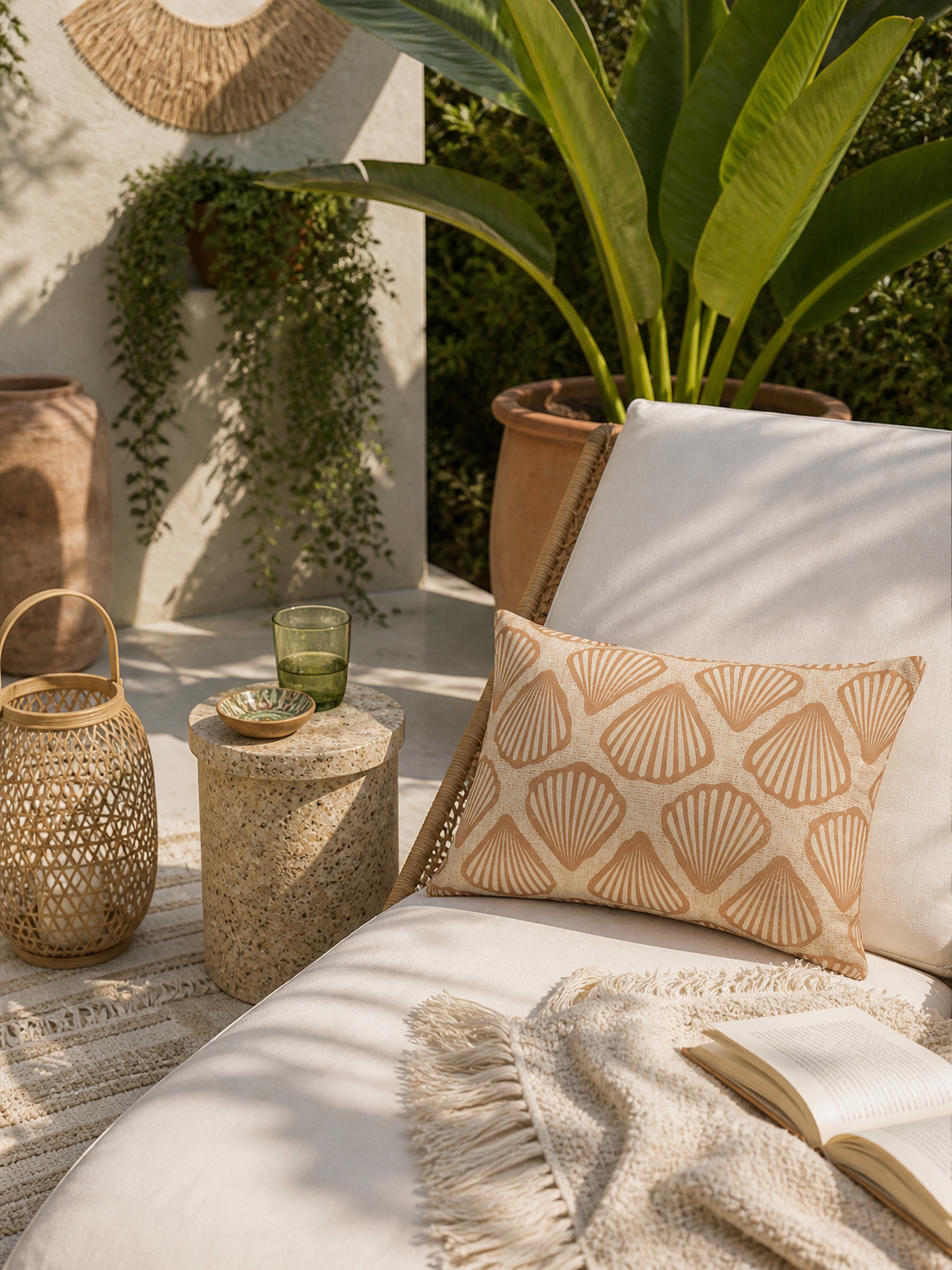 Sea Shell outdoor pillows on a cream daybed on a sunlit terrace