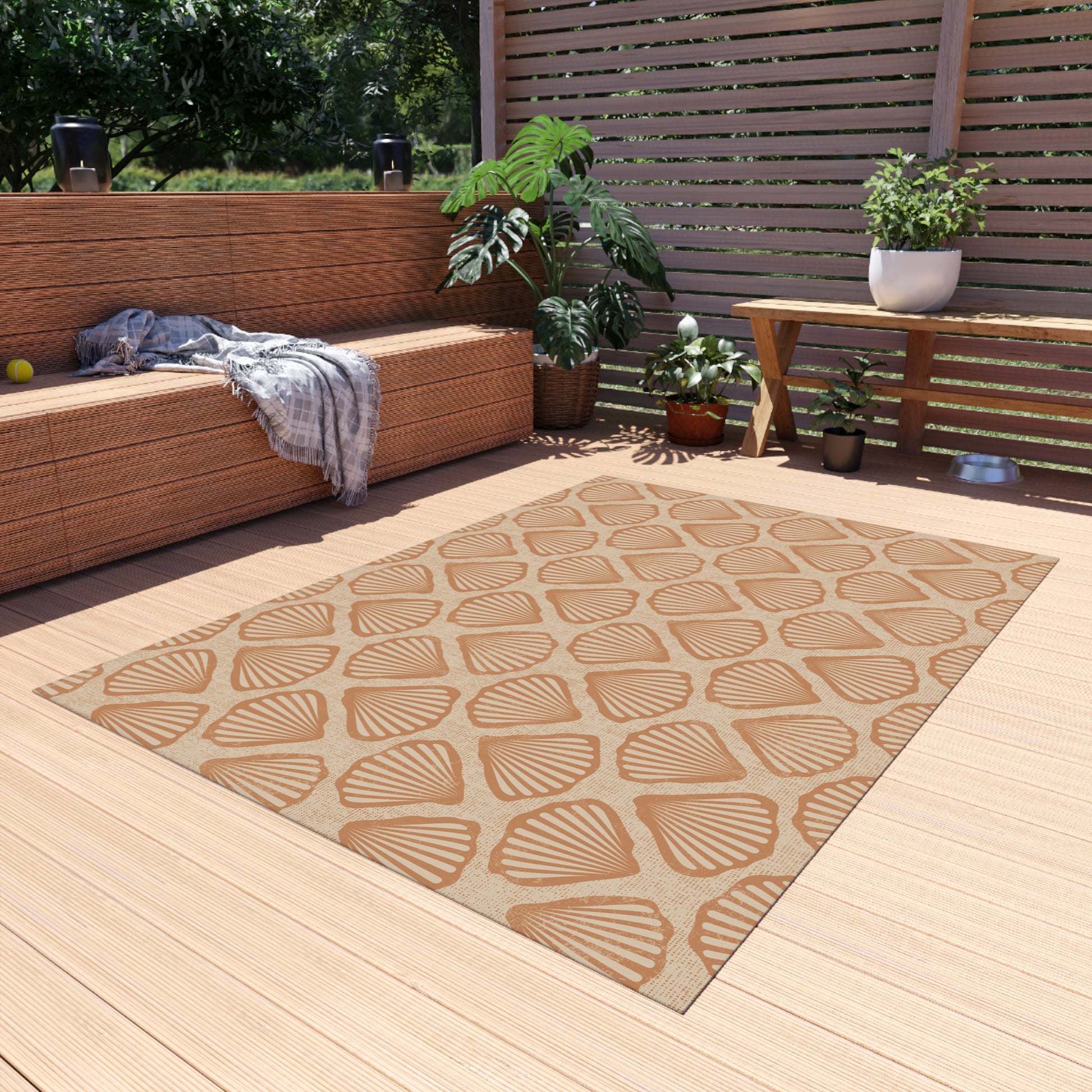 Sea Shell outdoor rug on a wooden deck beside a built-in bench and planters