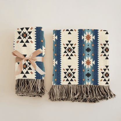 Two folded Southwestern woven blankets side by side, one tied with a ribbon, showing the front and the reverse side