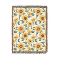 Sunflower woven blanket in cream with yellow sunflowers and green leaves, shown flat