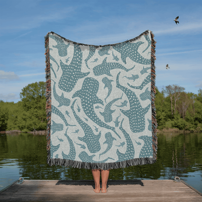 Person holding up the Whale Shark woven blanket on a jetty by the water