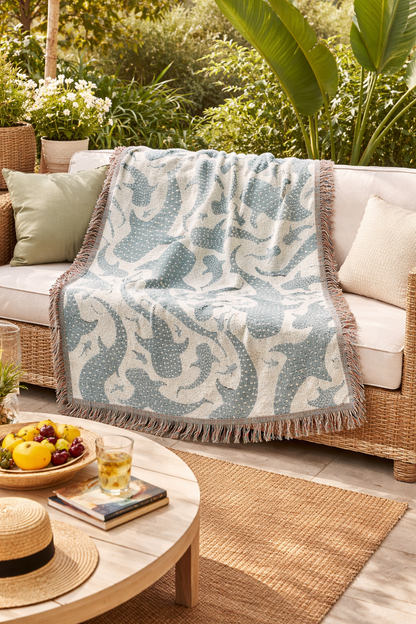 Whale Shark woven blanket over a rattan sofa on a terrace with tropical plants