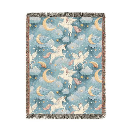 Woven blanket with cream winged unicorns, crescent moons, clouds and stars on a teal blue ground, shown flat