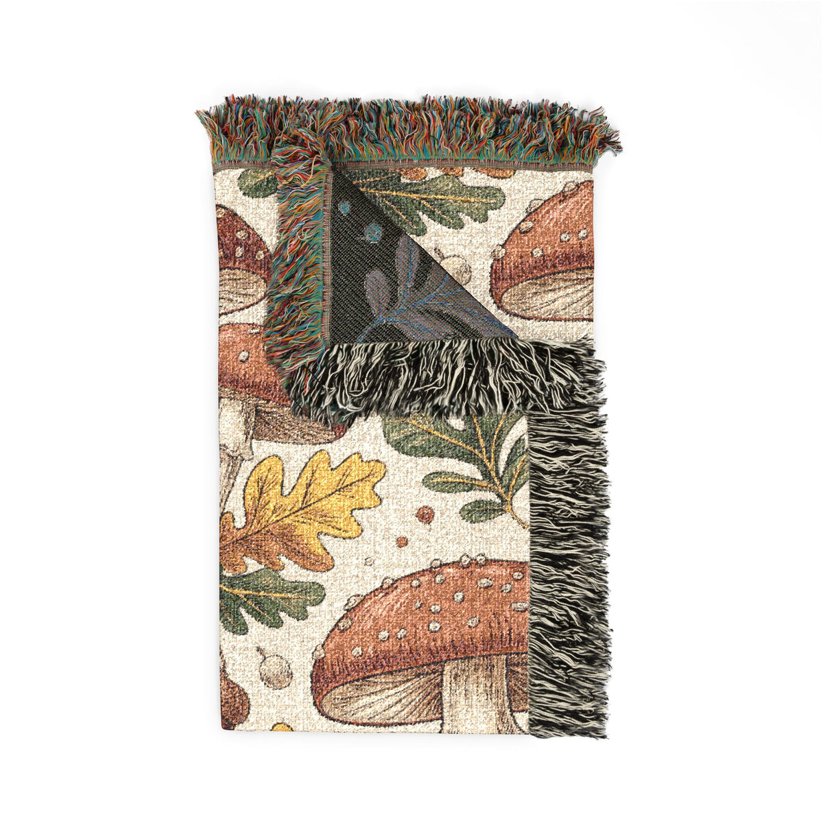 Folded corner detail of the woodland mushroom woven blanket showing the fringe edge
