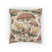 Woodland mushroom woven pillow featuring red-capped toadstools, golden oak leaves and acorns on a cream ground