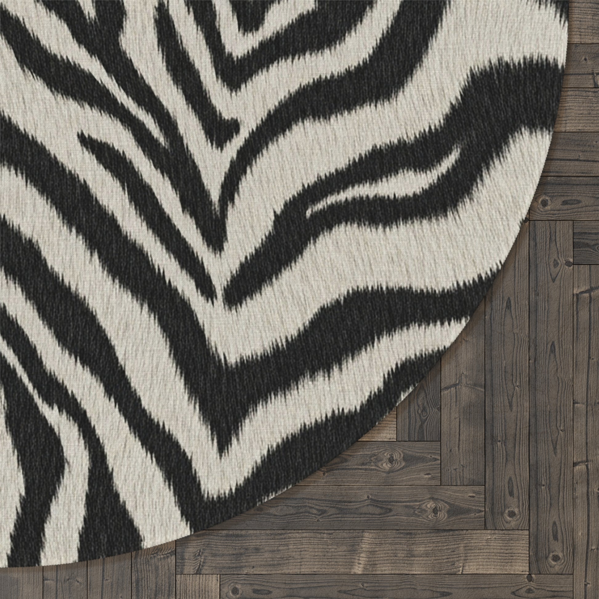 Close-up of the Zebra round rug edge against a dark wood floor
