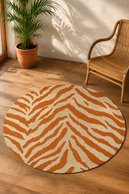 Terracotta zebra round rug beside a rattan chair and a potted plant