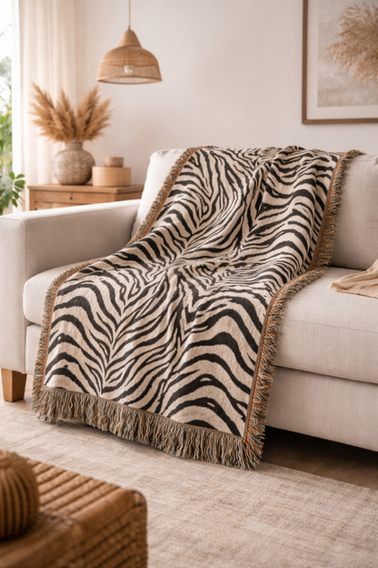 Zebra woven blanket draped over a cream armchair in a bright room
