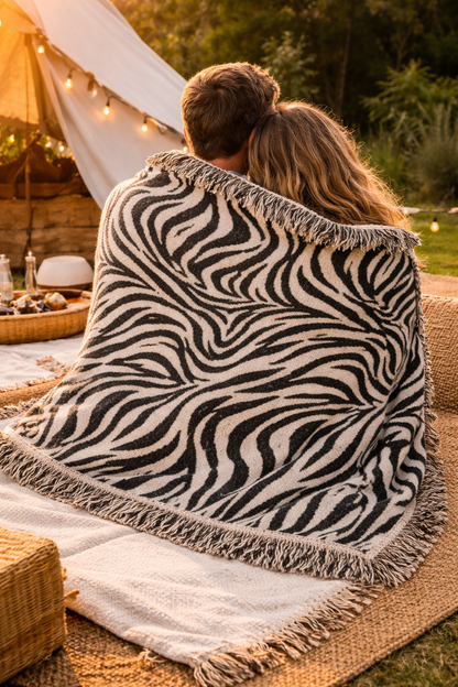 Woman holding up the Zebra woven blanket outdoors, showing its size