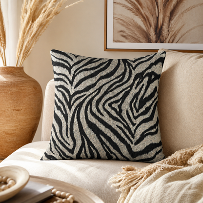 Zebra woven pillow on a cream sofa with pampas grass and framed art behind